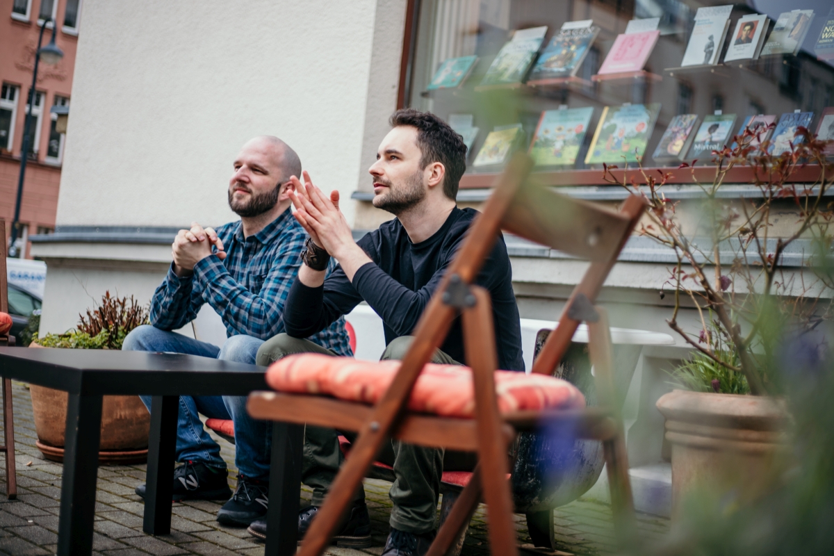 Alexander Senf und Alexander Büttner sitzen vor dem Buchladen Lessing und Kompanie und bereiten sich auf die Lesung vor.