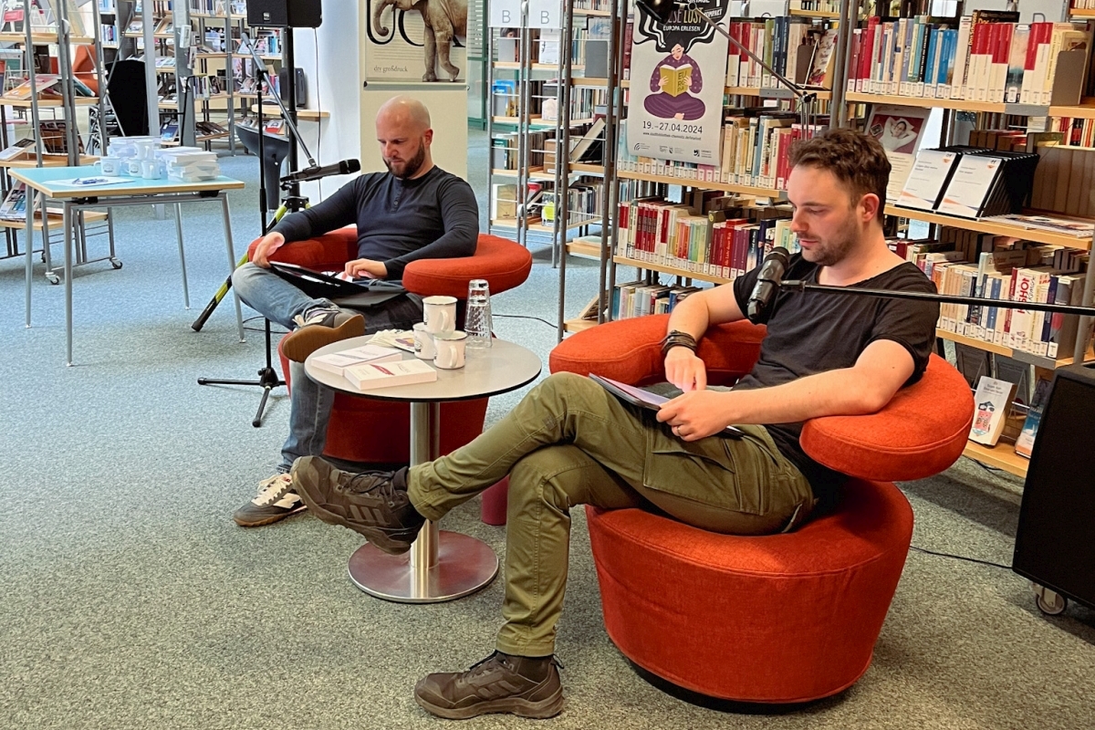 Alexander Büttner und Alexander Senf während der Lesung von der Seite fotografiert.