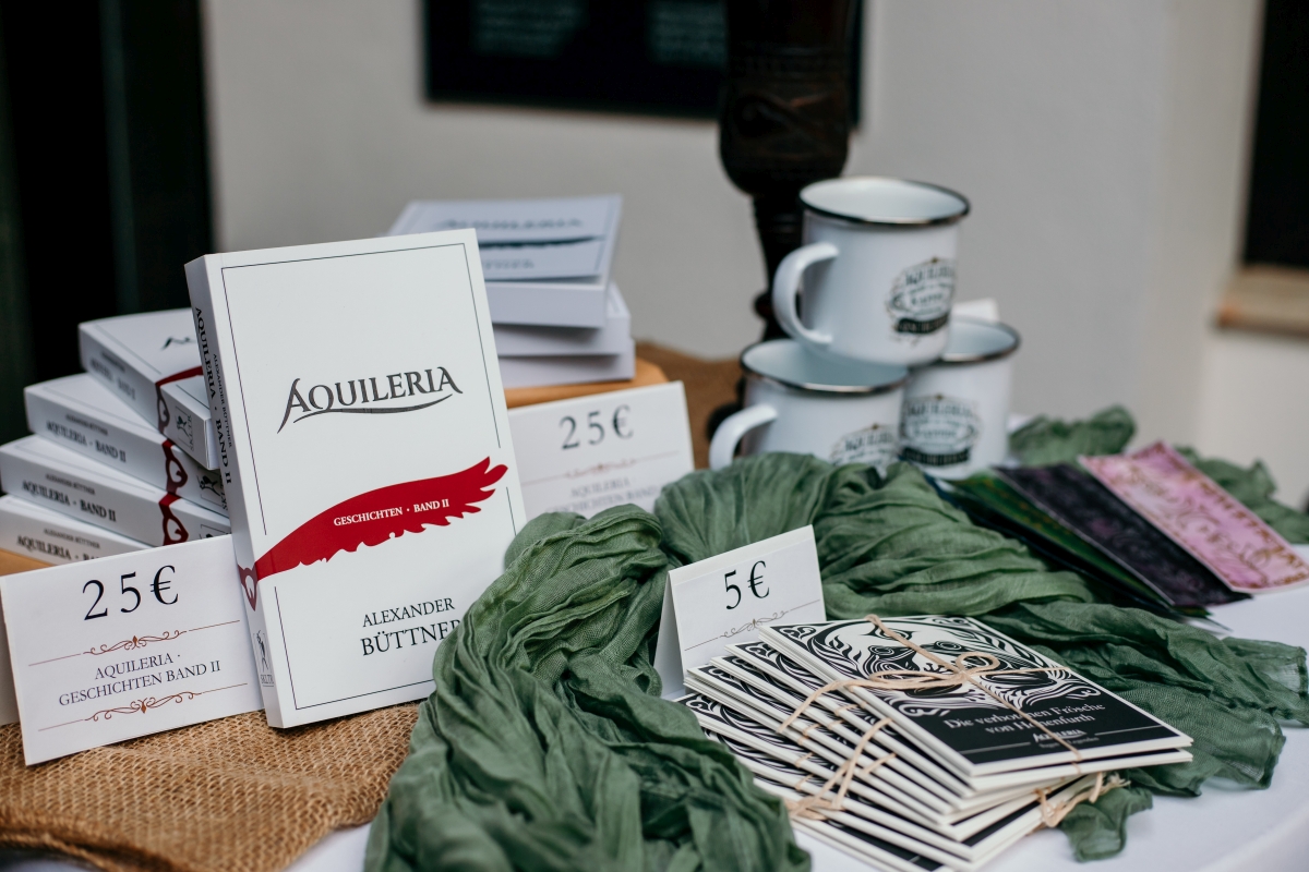 AQUILERIA Lesung bei der Vernissage von Claudia Pfeifer (3) Der AQUILERIA Bücherstand mit Büchern, Tassen, Postkarten und Lesezeichen.