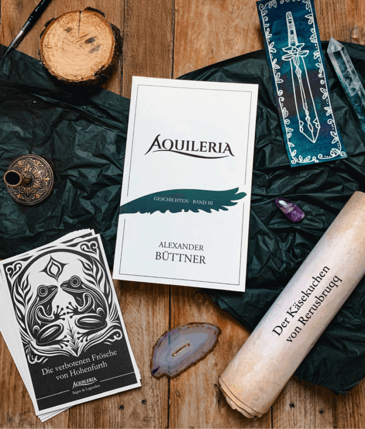 Das fantastische AQUILERIA Helden Unterstützungspaket bestehend aus dem Buch, einem Lesezeichen, einem Set von Sammelpostkarten und einer Schriftrolle mit der Kurzgeschichte "Der Käsekuchen von Rerusbruqq".